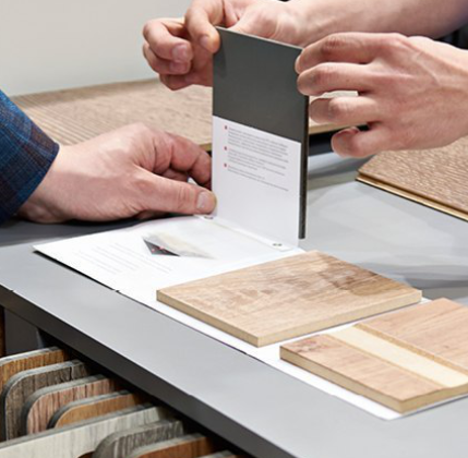 Kundenberatung im Fachhandel: Zwei Personen begutachten verschiedene Materialmuster für Bodenbeläge.