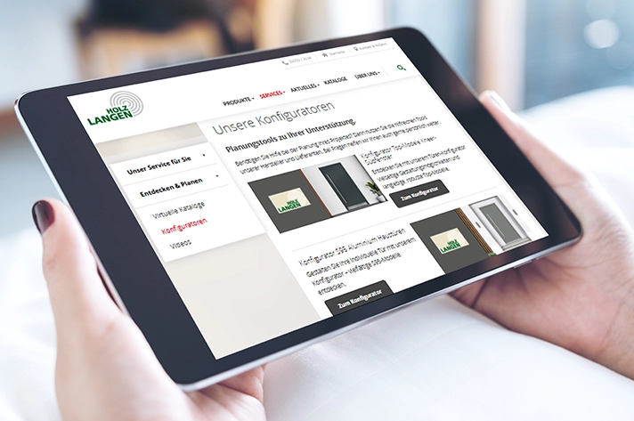 Person hält Tablet mit geöffneter Holz Langen Webseite und Konfigurator für Haustüren und Innenausbau.