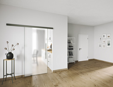 Moderner Wohnflur mit platzsparender Schiebetür auf Laufschiene und hellem Holzfußboden.