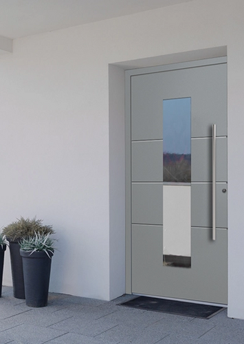 Moderner Hauseingang mit grauer Haustür und dekorativen Pflanzen.