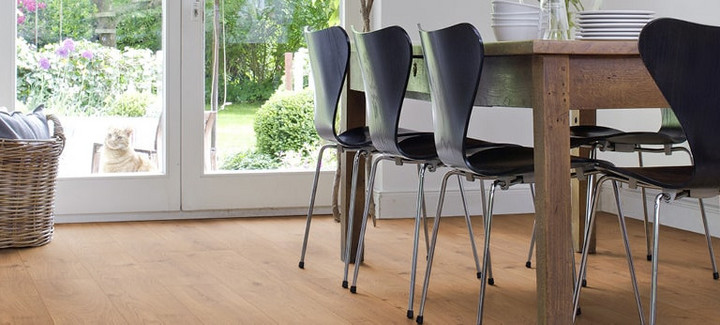 Das Esszimmer ist mit Laminat in hellem Holzfarbton ausgelegt. Ein massiver Esstisch aus Holz und leichte Stühle runden die Einrichtung ab.