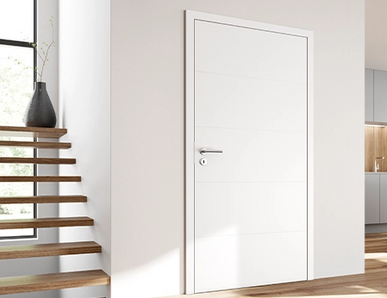 Helles, modernes Wohnambiente mit weißer Innentür, offener Küche und Essbereich mit schwarzen Stühlen.