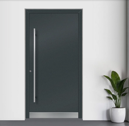 Moderne dunkelgraue Haustür mit langem, schlanken Edelstahlgriff in einer minimalistischen Eingangssituation.