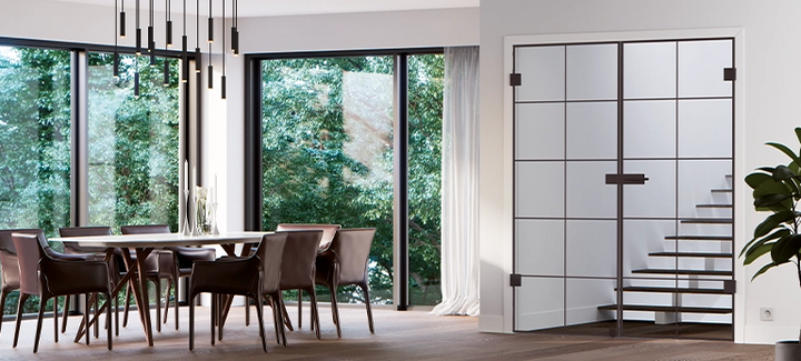 Schwarze Lofttür mit Sprossen als Raumtrenner neben großen Fenstern in einem modernen Essbereich.