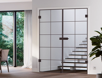 Schwarze Lofttür mit Sprossen als Raumtrenner neben großen Fenstern in einem modernen Essbereich.