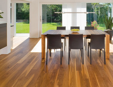 Die Küche ist mit massivem Boden ausgelegt. In der Mitte steht ein massiver Tisch mit Stühlen, und durch die Glasfenster sieht man den Ausgang zur Terrasse und zum Garten.